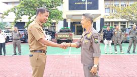 Kiri-kanan: Zamhur ST MM bersalaman dengan Ahmad Zaki MM setelah serah terima jabatan PLt Kasatpol-PP Kampar