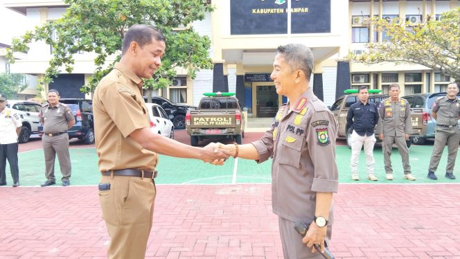 
					Kiri-kanan: Zamhur ST MM bersalaman dengan Ahmad Zaki MM setelah serah terima jabatan PLt Kasatpol-PP Kampar